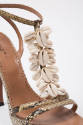 Detail view of one snakeskin sandal showing three rows of cowrie shells on the T-strap
