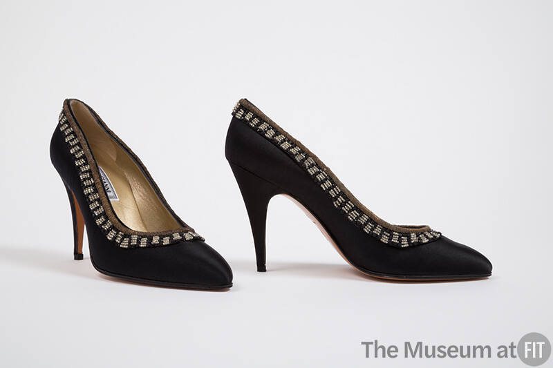Pair of black high heel pumps with gold bullion and black and clear breaded trim around topline…