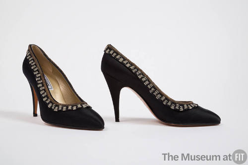 Pair of black high heel pumps with gold bullion and black and clear breaded trim around topline…