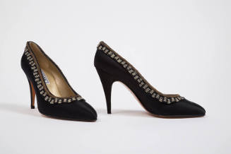 Pair of black high heel pumps with gold bullion and black and clear breaded trim around topline…
