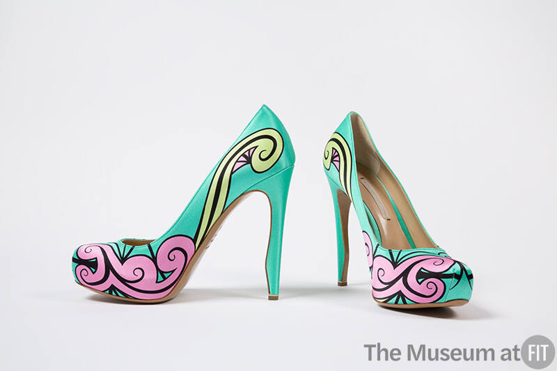 Pair of bright aqua green high heel pumps with pink, light green and black swirl design across …