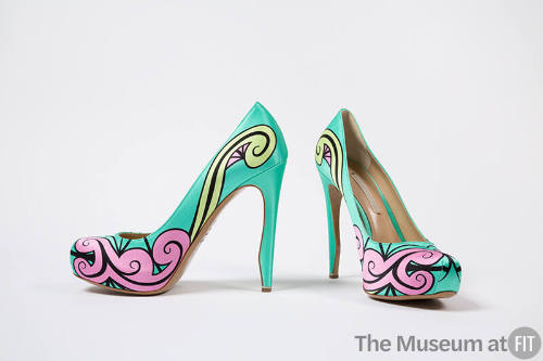 Pair of bright aqua green high heel pumps with pink, light green and black swirl design across …