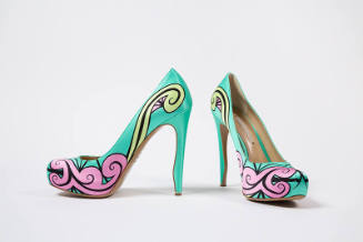 Pair of bright aqua green high heel pumps with pink, light green and black swirl design across …