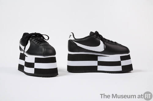 Black lace-up sneakers with black and white checkerboard platform soles