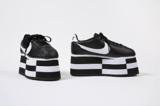 Black lace-up sneakers with black and white checkerboard platform soles