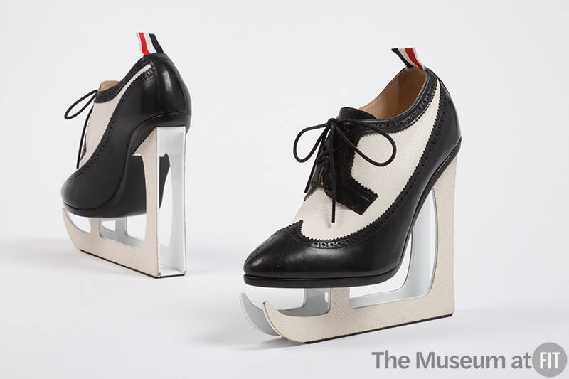 Black and white leather wingtip lace-up shoes with white ice skate blade platforms