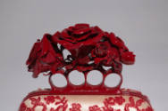 Detail of handbag handle with red metal knuckle holes and red roses