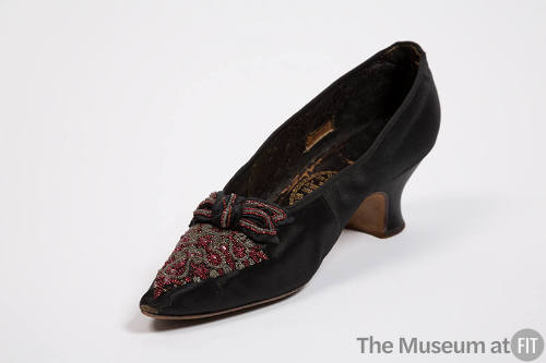 Black evening pump with pointed toe, clear and red beads on vamp with beaded bow and low Louis …
