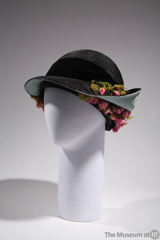 Black straw hat with deep round crown and black band, light blue lined brim turned up at back a…