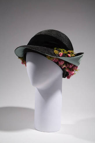 Black straw hat with deep round crown and black band, light blue lined brim turned up at back a…