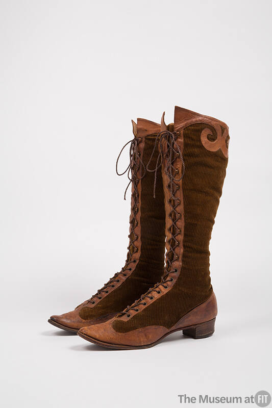 Pair of brown corduroy boots with brown leather trim around toe, vamp, heel and around center l…