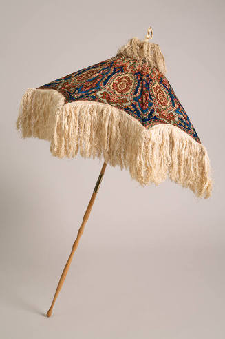 Parasol in blue, rust, green, rose, and beige paisley print with long ivory fringe at the cap a…