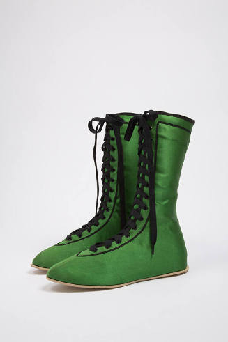 Pair of bright green calf height shoes with eyelet lace up front, black laces and black trim
