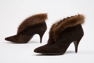 Pair of brown suede ankle boots with pointed toe, stiletto heel and brown mink fur trim around …