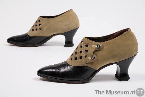 Pair of tan suede shoes with pointed black leather toe and Louis heel, latticework perforations…