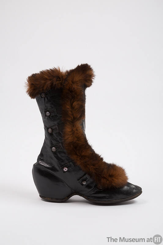 Black leather calf height boot with brown fur trim, low wedge heel and side button and tab clos…