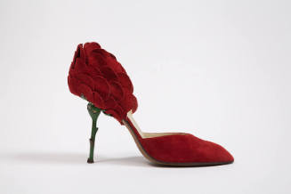 Red suede high heel shoe with green metal stem heel and petal back, open sides