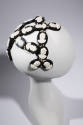 Head band hat with oval black discs with white cameos 