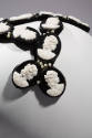 Detail of head band hat with oval black discs with white cameos and pearls