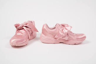 Pair of entirely pink lace-less athletic sneakers with large bow tie closure