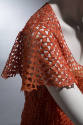 Detail view of openwork cap sleeve on orange evening dress