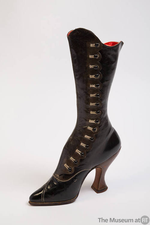 Tall black leather boot with side buttons on scalloped edge with high heel and extreme curved i…