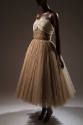 Alternate view of tan evening gown with dim lighting and dark background