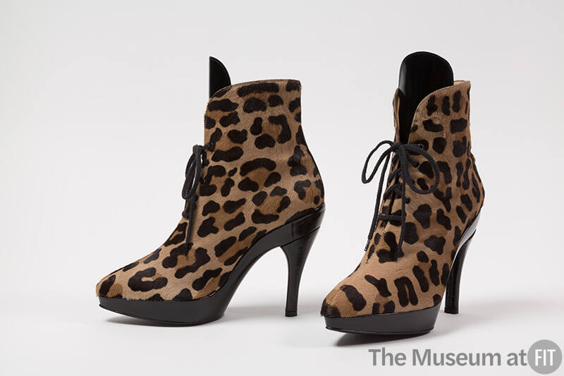 Pair of leopard print high heel lace up ankle boots with black tongue, platform sole and heel