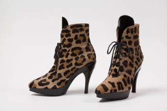 Pair of leopard print high heel lace up ankle boots with black tongue, platform sole and heel