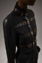 Detail view of black suit jacket showing leather bands down shoulders and arms, around collar a…