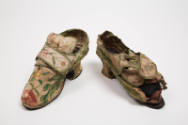 off white shoes with large, embroidered floral design with small heel. left shoe is cleaned and…
