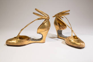 Gold metallic evening shoes with rhinestone encrusted voided arch, wedge, and ankle tie straps