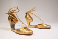 Gold metallic evening shoes with rhinestone encrusted voided arch, wedge, and ankle tie straps