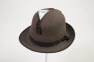 Alternate view of man’s brown charcoal wool hat showing reverse side of condom in zippered comp…