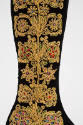 Detail of predominantly yellow, symmetrical embroidery on boot