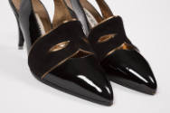 Detail of front of shoes black suede mask with gold trim and pointed toe