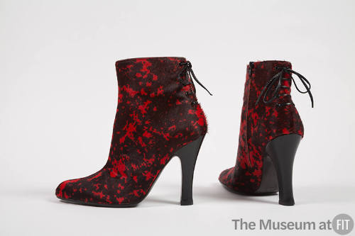 Pair of black calf hair ankle boots with red splatter design, mock lacing up center back and hi…