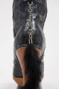 Detail of animal skin embossed boot heel with silver chain and fur tail zipper pull