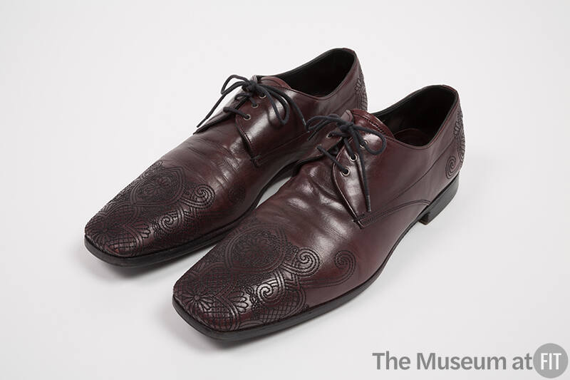 Man's dark red/brown lace up shoes with topstitched design of scrolling lines, swriling clouds,…