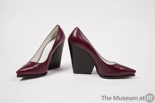 Pair of burgundy pumps with black high wedge heel and pointed toe