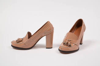 Pair of beige patent leather high heel loafers with tassels on vamp 