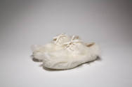 Pair of white faux fur lace up sneakers with textured soles