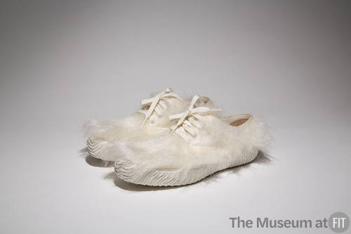 Pair of white faux fur lace up sneakers with textured soles