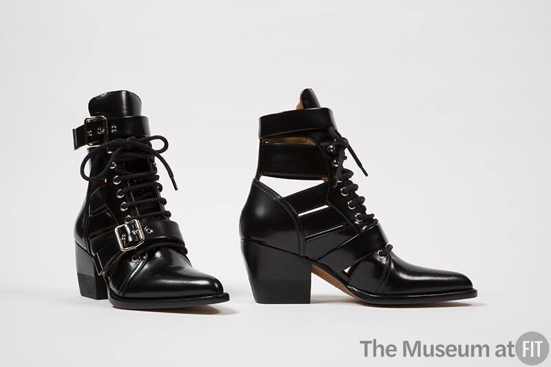 Pair of black lace up ankle boots with side cut outs and straps and buckles across vamp and aro…