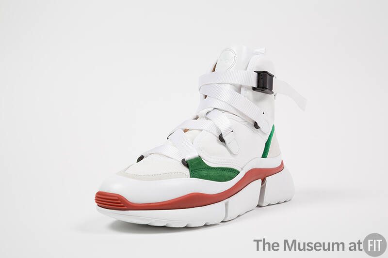 White high top sneaker with green and red accents, nylon strap laces and platform sole