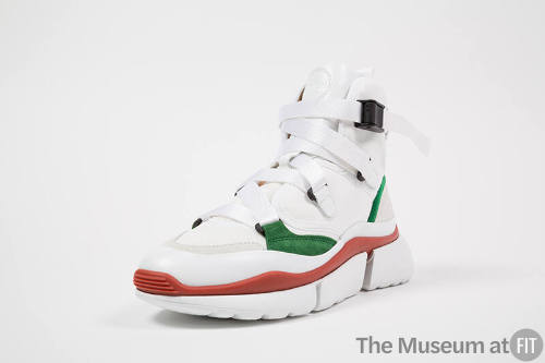 White high top sneaker with green and red accents, nylon strap laces and platform sole