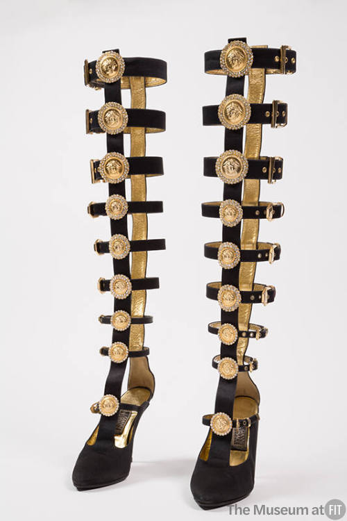 Pair of black over-the-knee stiletto heel gladiator boots of buckle straps extending upwards fr…