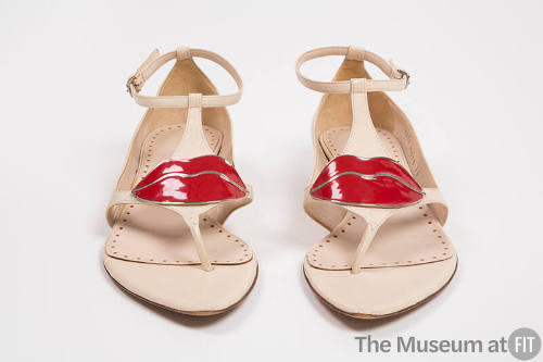 Beige thong sandals with enamel red lip ornament at t-strap, ankle straps