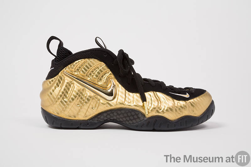 Metallic gold sneakers with gold Swoosh logo, black eyestay,  laces and soles