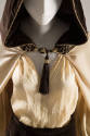 Beige wool cape with brown hood that has a tassle in the front